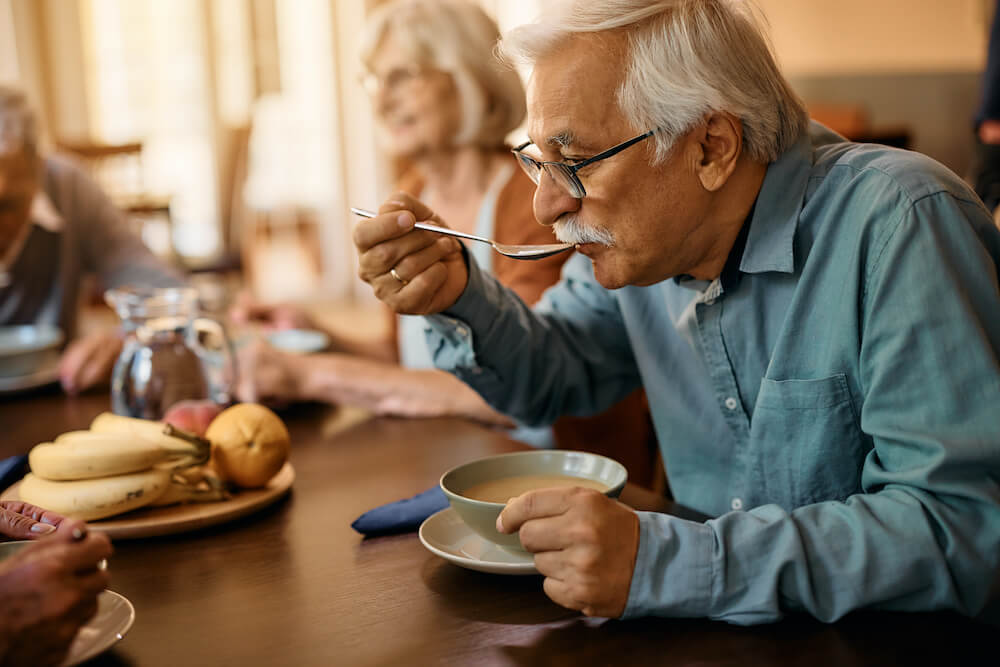 A group of older people eating at a table.