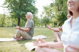 A group of people meditating in a park.
